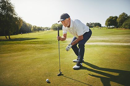 older man lining up golf shot